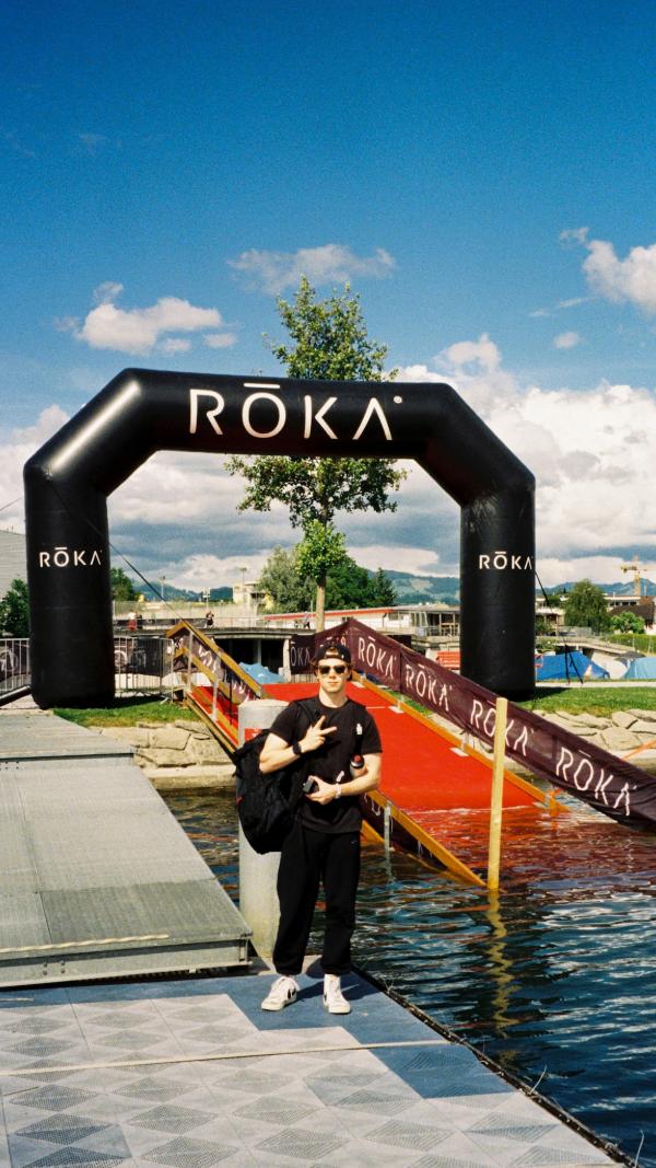 Aidan standing by the ROKA swim arch on a sunny day