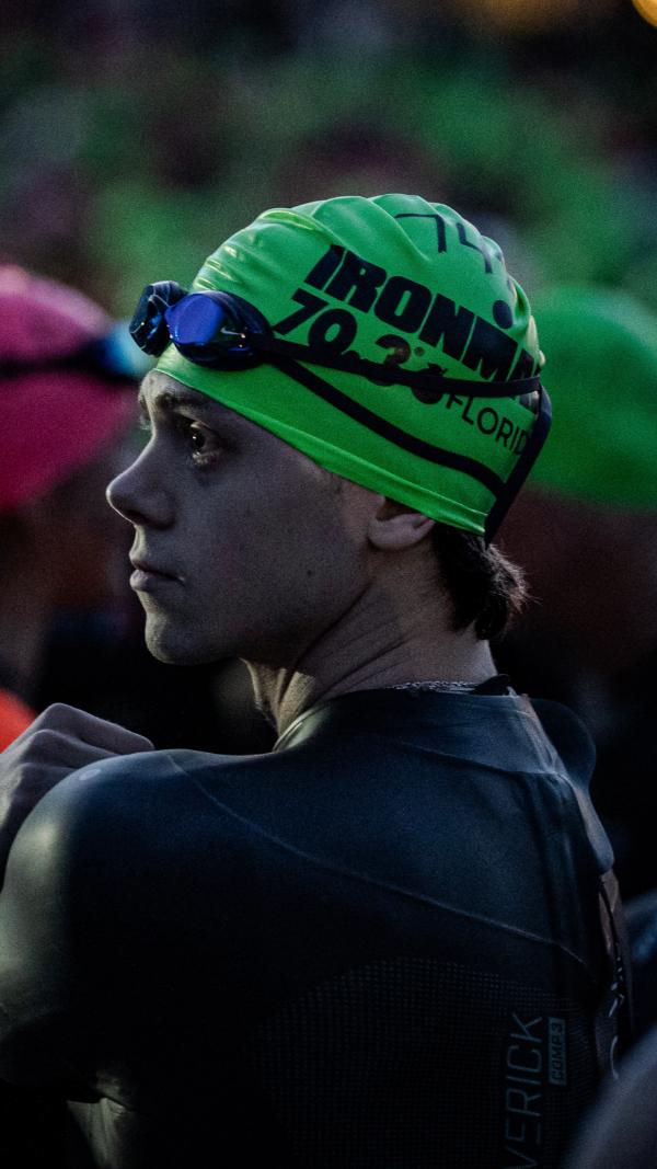 Aidan in a green IRONMAN swim cap before the start